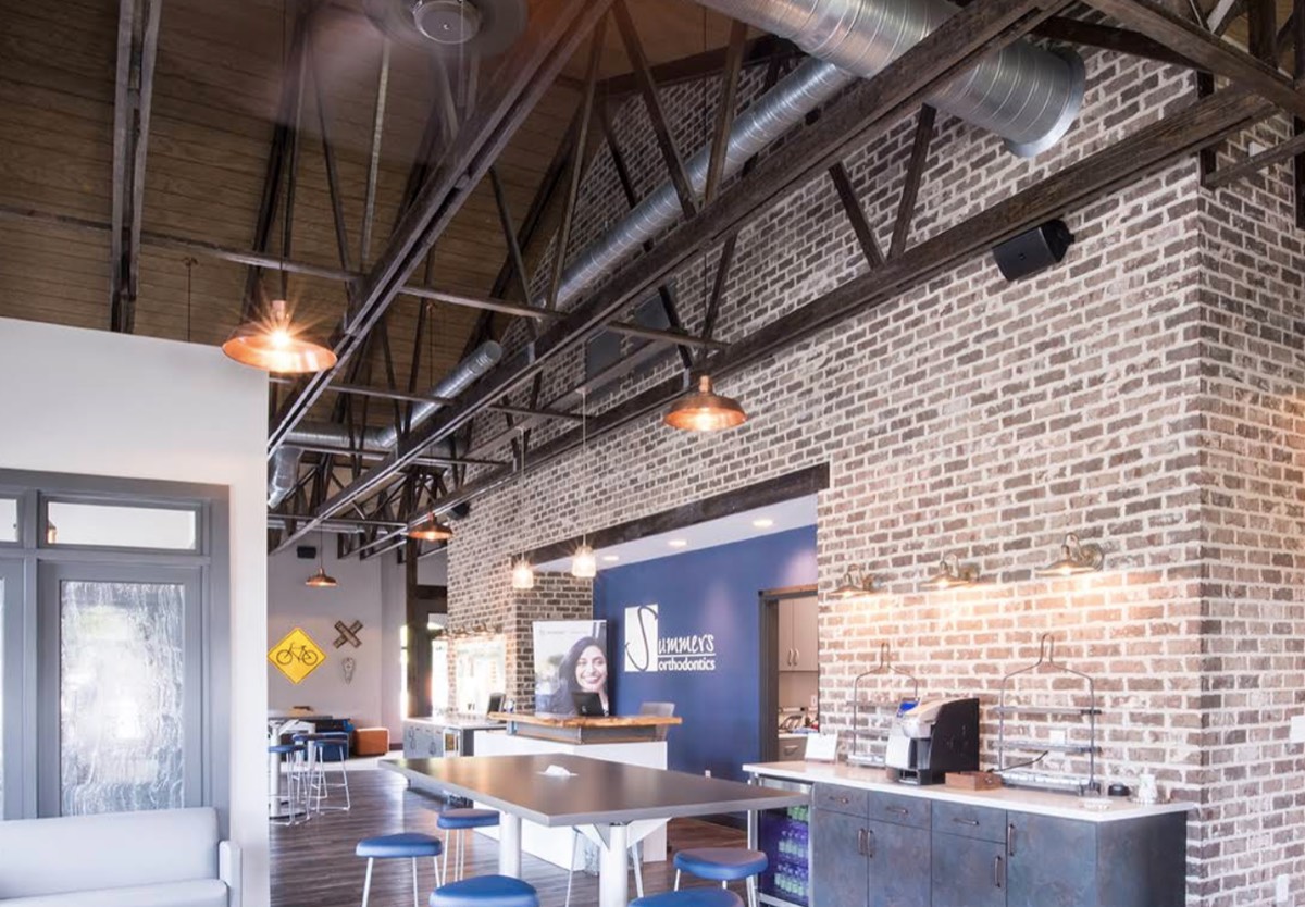 The Summers Orthodontics lobby with exposed brick walls, a coffee bar and open seating