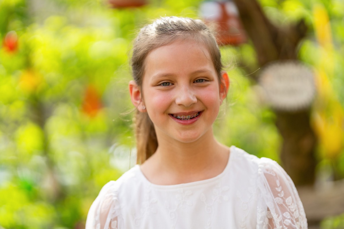 Young girl with braces smiling outdoors